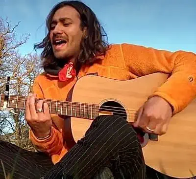 Maxim Baldry singing with playing guitar